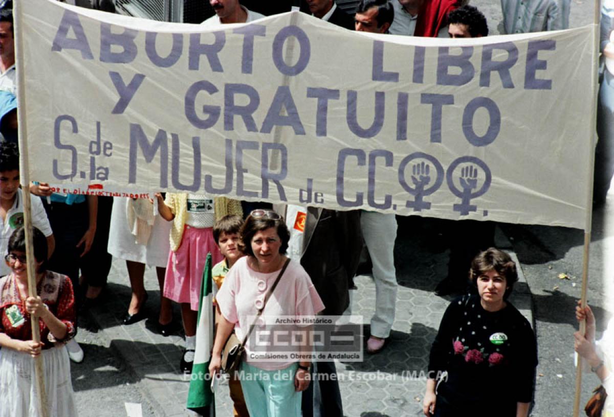 Pancarta de la secretaría de la Mujer de CCOO en la Manifestación del 1º de mayo de 1985 exigiendo ‘’Aborto, libre y gratuito’’. En el centro, Florencia Cano, del Sindicato de Química de CCOO. Sevilla, 1 de mayo de 1985. Foto de María del Carmen Escobar, Maca (AHCCOOA).